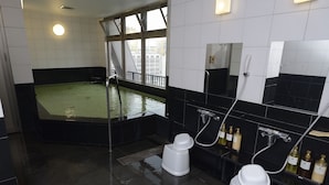 A modern bathroom with a large bathtub, a shower area, and a toilet. - Natural Hot Spring Midosuji Hotel (Osaka)