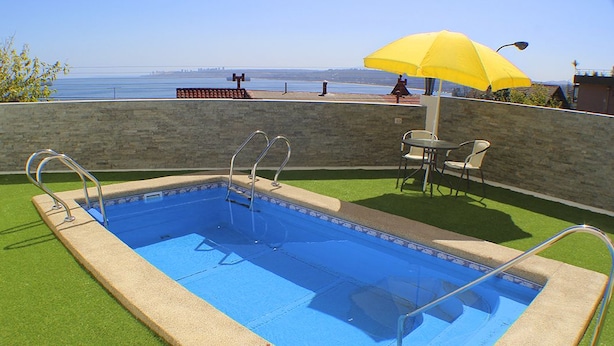 Una piscina al aire libre, tumbonas