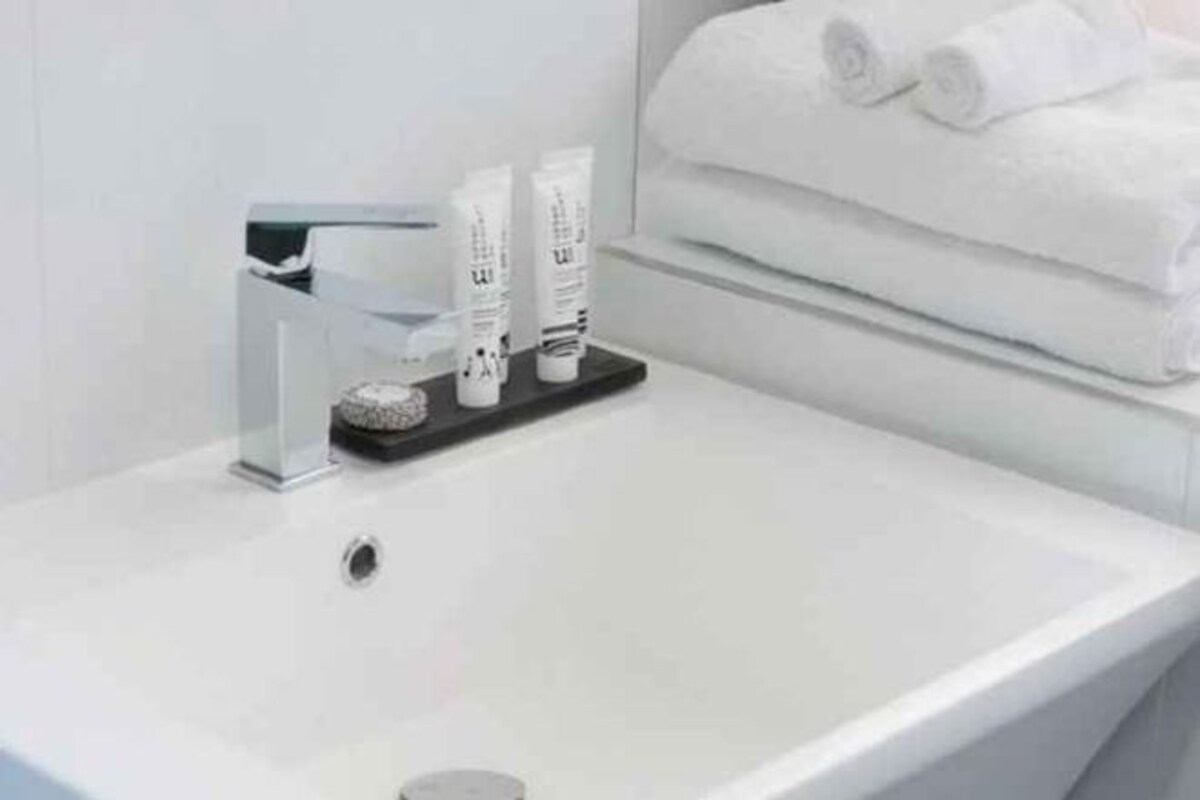 A white sink with toiletries and towels.