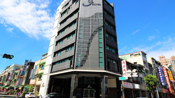 Un hotel moderno con un diseño vertical distintivo, varios pisos y una entrada destacada.