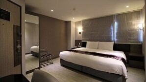 Una habitación de hotel moderna con una cama grande, un escritorio y una silla.