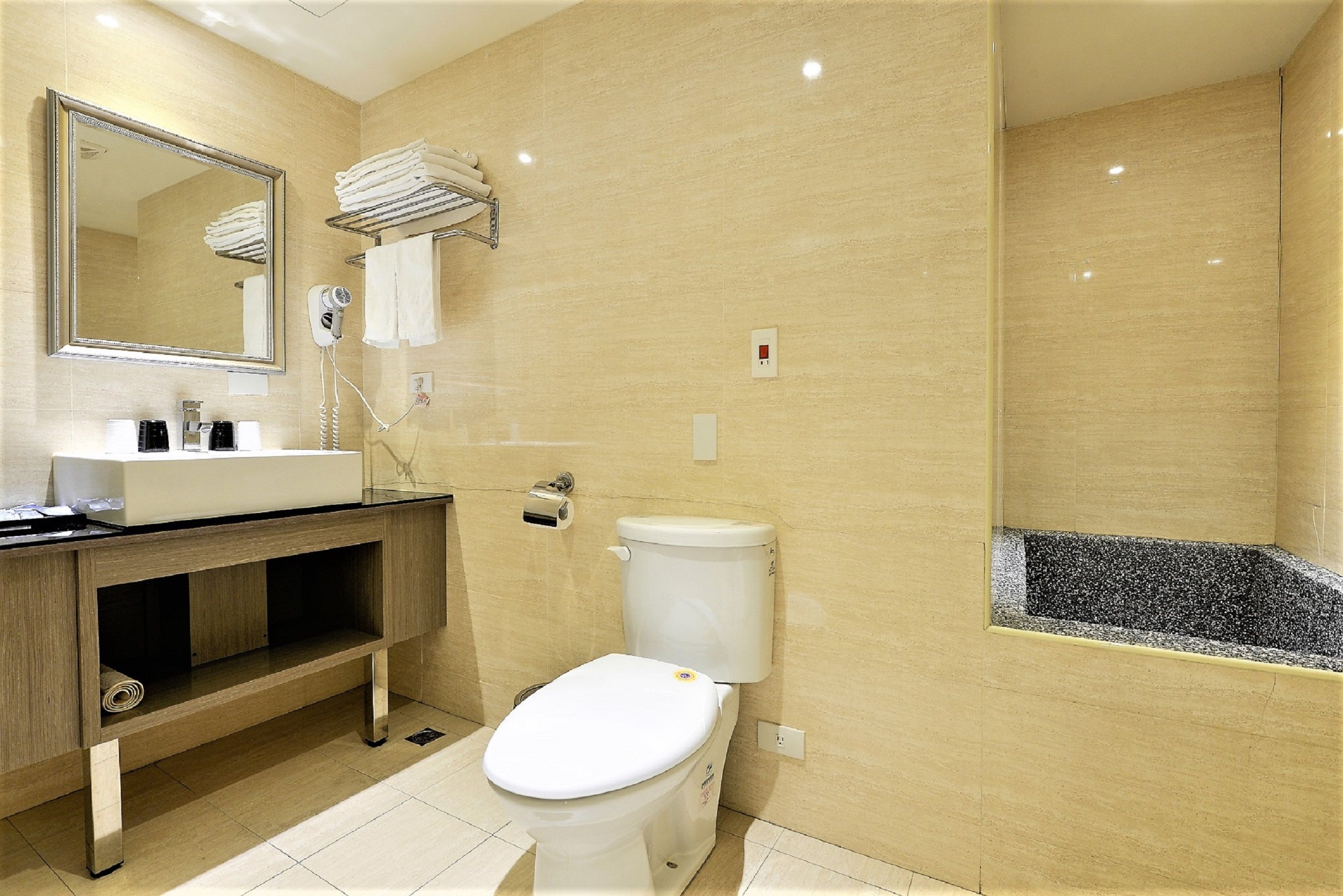 Une salle de bain moderne équipée de toilettes, d’un lavabo et d’un miroir.