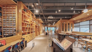 A library with wooden bookshelves, tables, and chairs. - Jeonju YeongHwa Hotel (Jeonju)