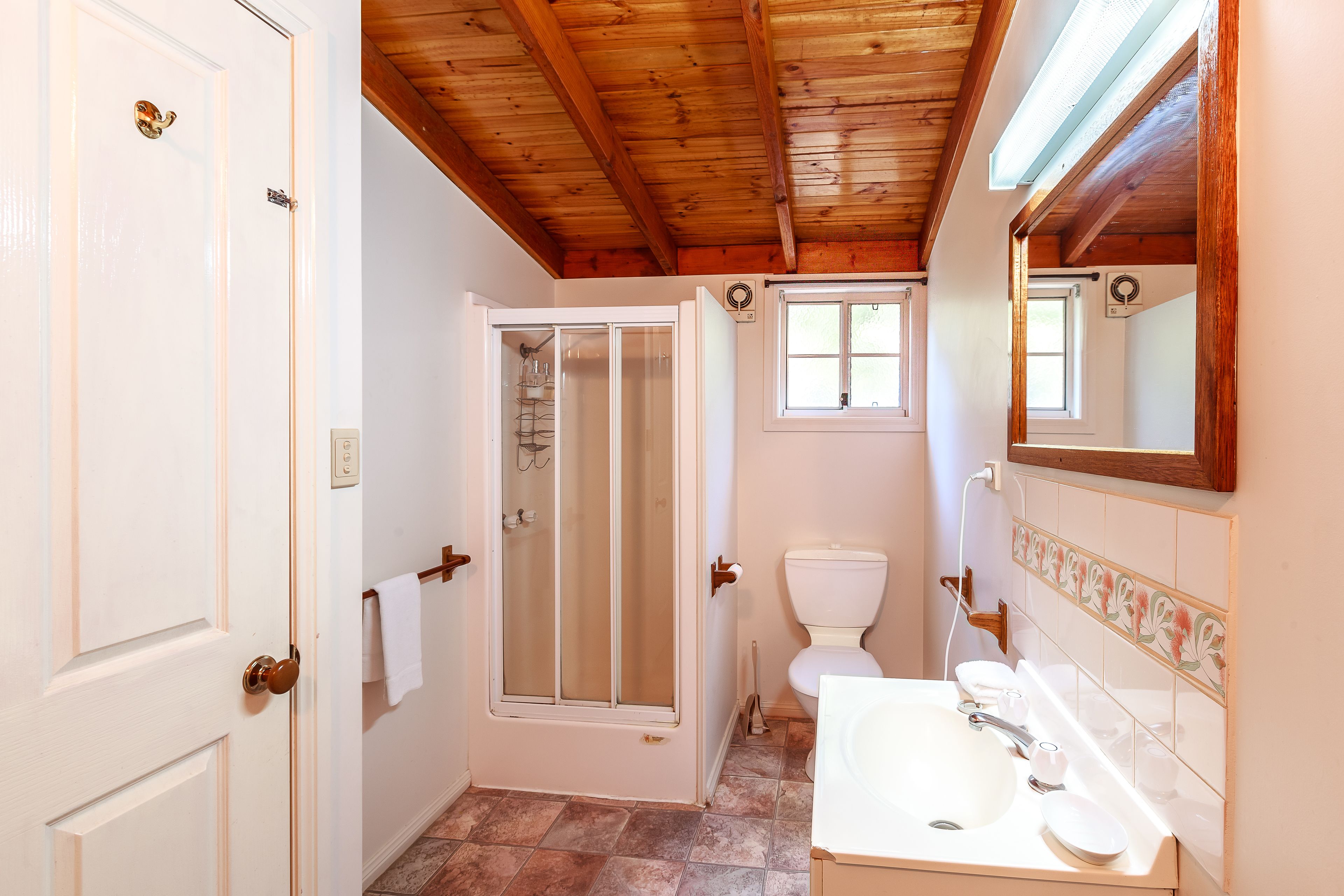 Une salle de bain avec douche, toilettes et lavabo.