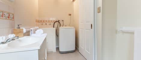 Un baño con lavamanos blanco, inodoro y ducha.