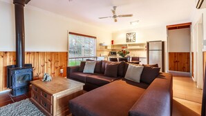 Una sala de estar acogedora con chimenea, un sofá y una mesa de centro.