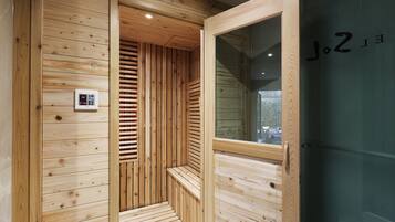A wooden sauna with a control panel, a bench, and a glass door.