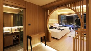 A modern hotel room with a wooden interior, a large bed, a desk, and a view of the outside. - Hotel SoL (Jeonju)