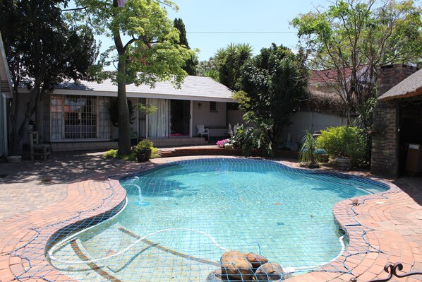 Una piscina al aire libre, sombrillas