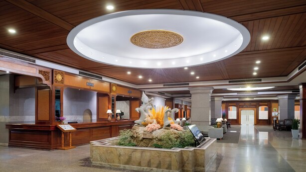 A hotel lobby with a reception desk, a decorative fountain, and a modern ceiling design. - Star Convention Hotel (Rayong)