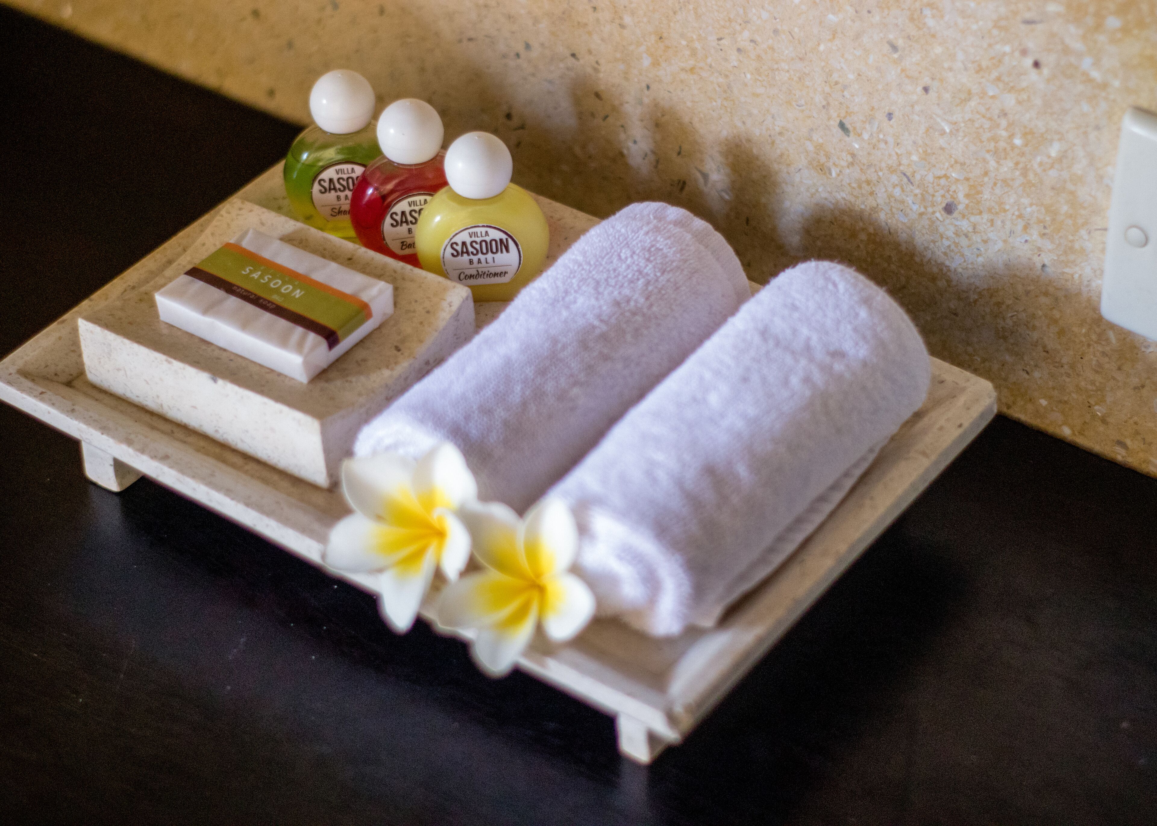 A tray with toiletries, towels, and a bar of soap.
