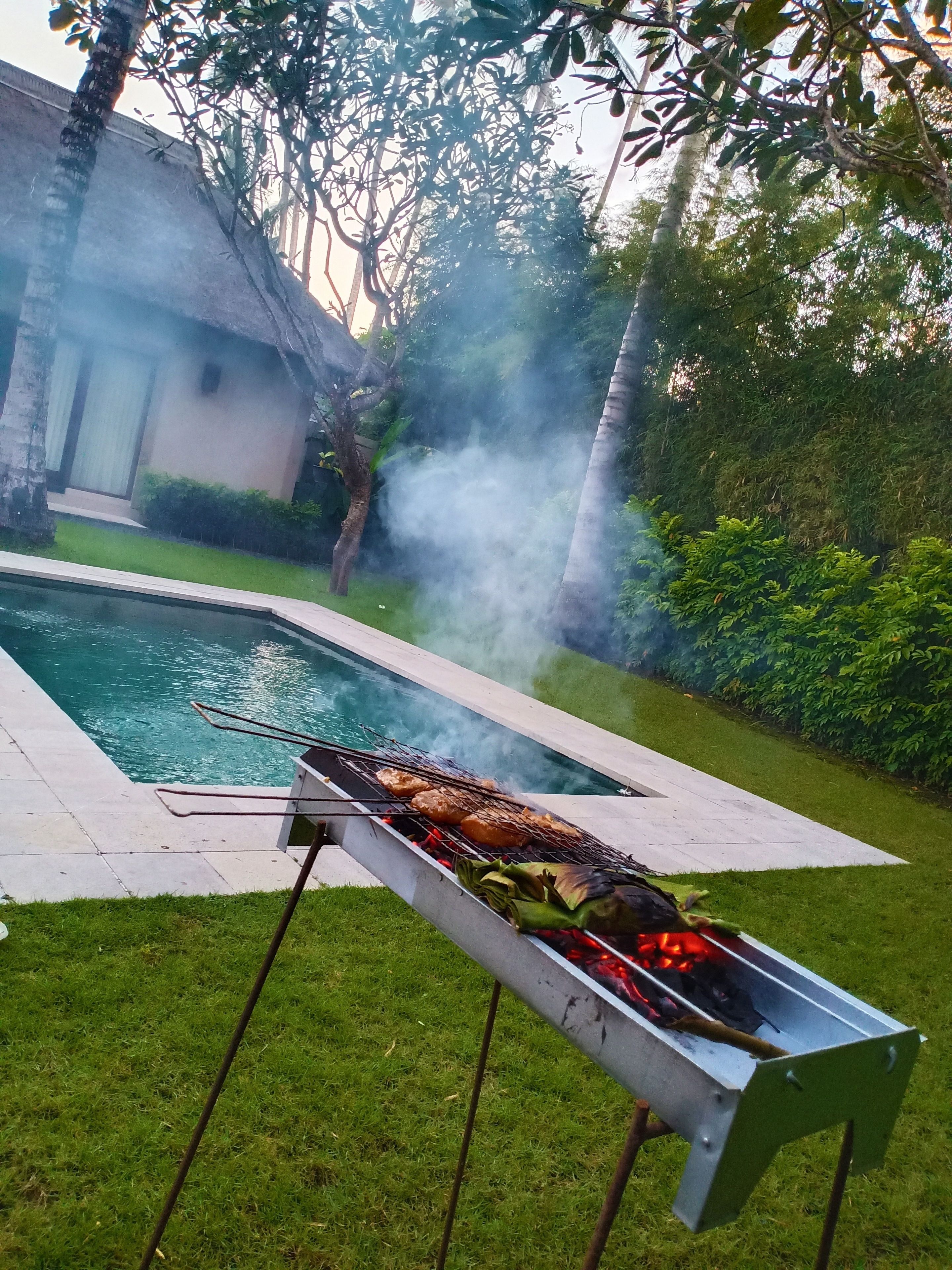 Patio con piscina, una parrilla y una casa.