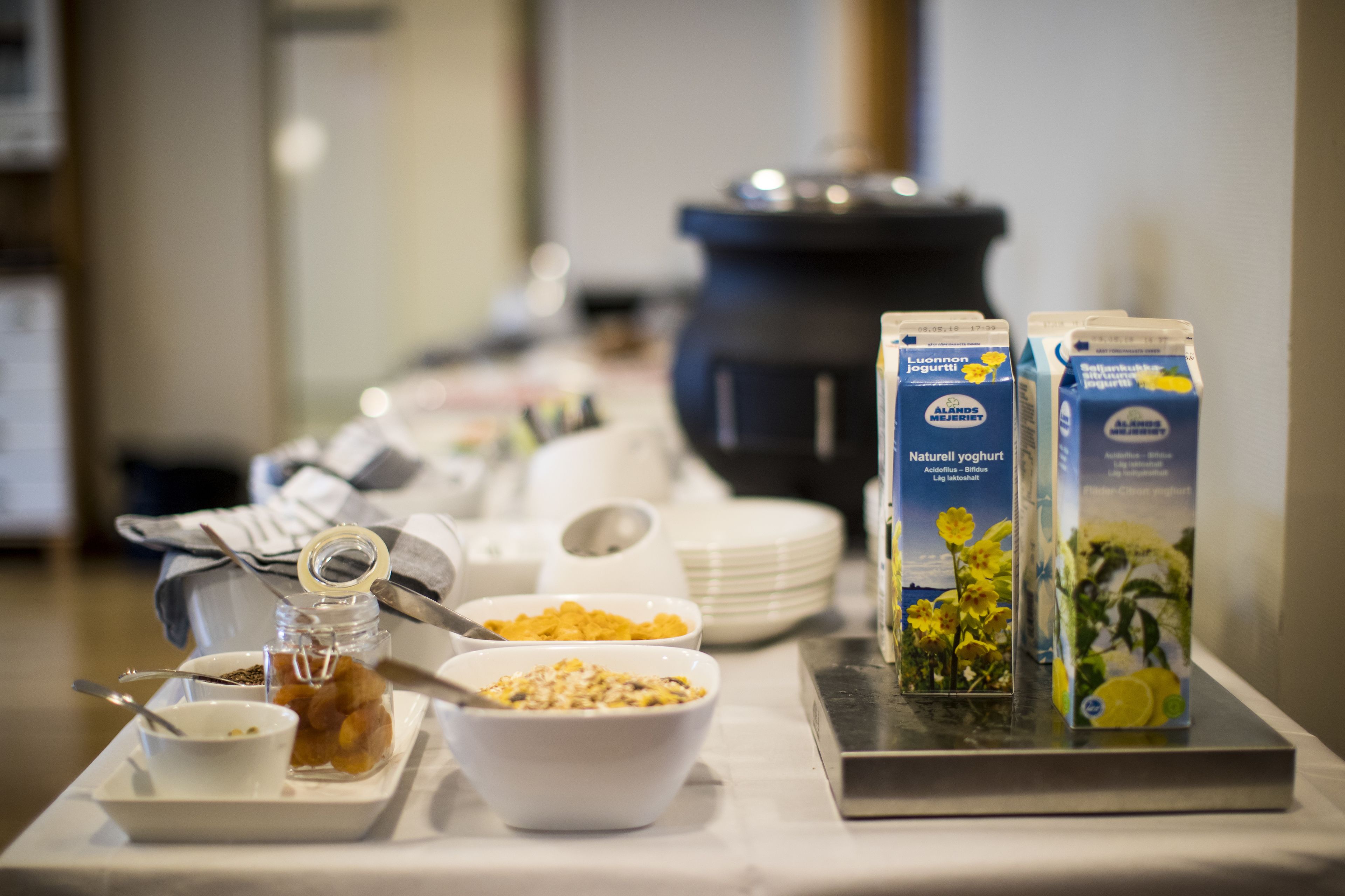 Buffet de café da manhã com diversos alimentos e caixas de leite.