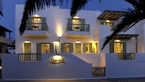 A two-story building with balconies, a sign reading "Olivier's", and a gated entrance. - Almyris (Milos)