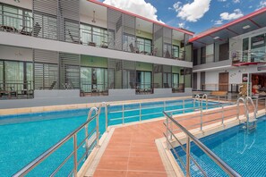 A hotel with a swimming pool, multiple balconies, and a lobby area. - Chayadol Resort (Chiang Rai)