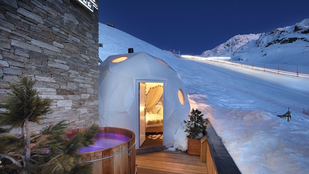 A snow-covered slope with a wooden sauna and a stone building. - Hôtel Pashmina (Les Belleville)