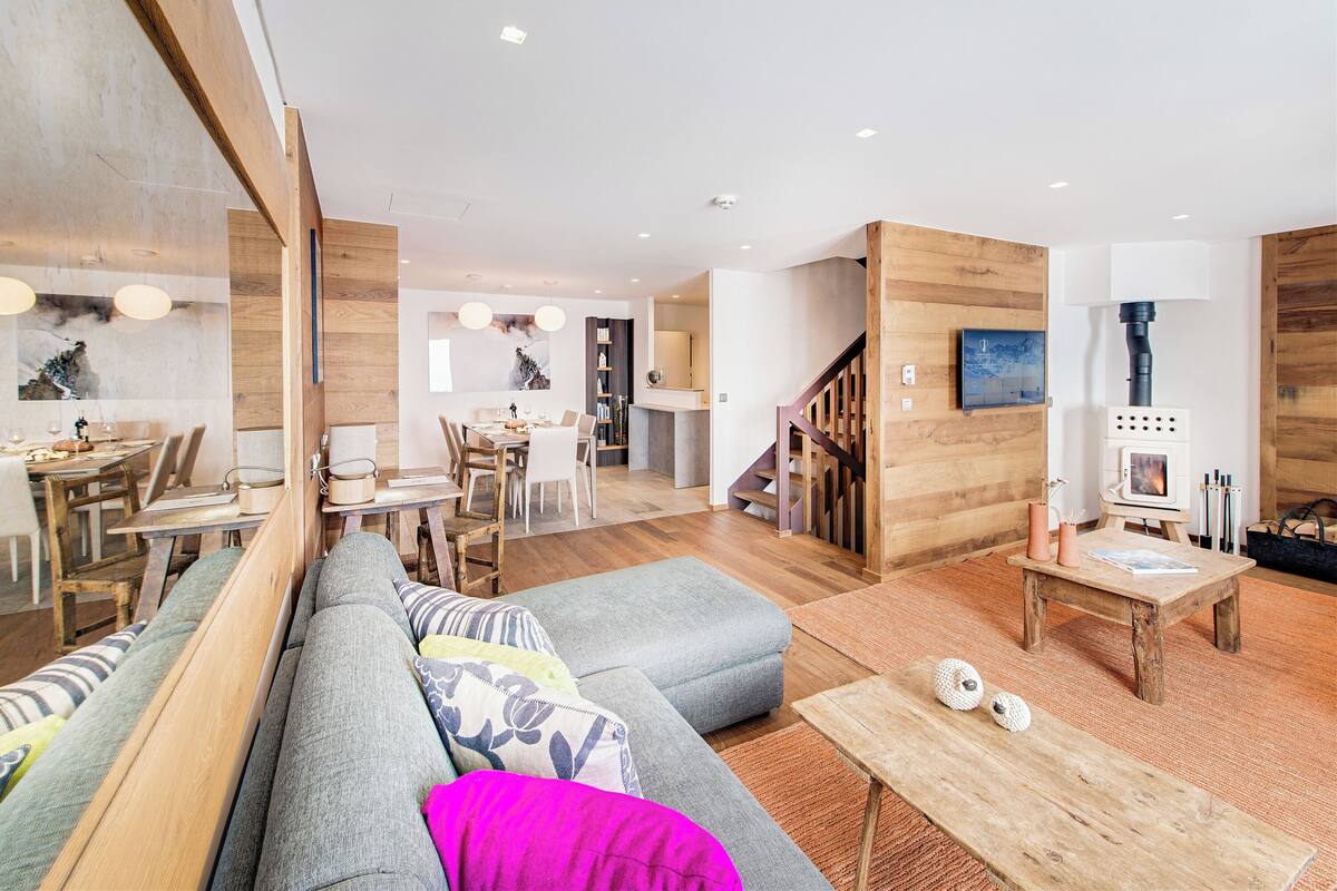 Ein modernes Wohnzimmer mit Sofa, Couchtisch und Kamin.