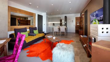 A modern living room with a sofa, coffee table, and a vibrant orange rug.