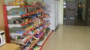 Passís d'un supermercat amb estantes plenes de llaminatures, begudes i productes per a la llar.
