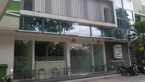 Un hotel anomenat 'Simple Inn' amb façana moderna, grans finestres i zona d'seients a l'aire lliure.