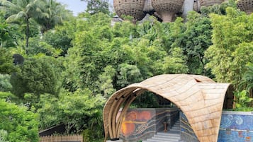 A staircase with a bamboo archway leading to a building with multiple cylindrical structures.