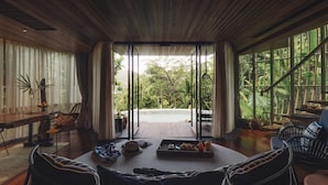 A spacious room with a wooden ceiling, large windows, and a view of lush greenery. - Keemala (Kamala)