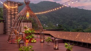 A rooftop terrace with a decorative structure, string lights, and potted plants. - Keemala (Kamala)