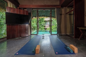 A yoga room with mats, a bench, and a TV.