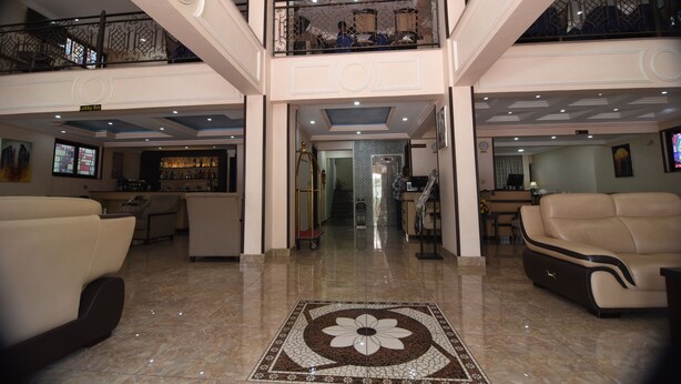 A spacious lobby with a central floral-patterned floor, a bar area, and seating arrangements. - Southern Addis Hotel (Addis Ababa)