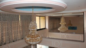 A room with ornate chandeliers, patterned wallpaper, and a large mirror reflecting the ceiling design. - Southern Addis Hotel (Addis Ababa)