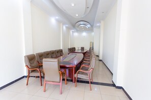 A conference room with a long table and chairs, white walls, and recessed ceiling lighting. - The Mirror Hotel (Kigali)