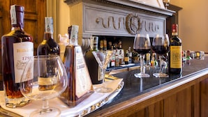 Una zona de bar con varias botellas y copas de vino y licores.