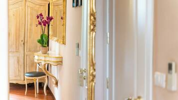 A room with a wooden wardrobe, a vanity with a mirror, and a chair.