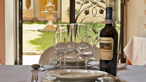 Una mesa servida con copas de vino, una botella de vino Castelgiocondo y platos.