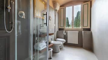 A modern bathroom with a glass shower enclosure, a toilet, and a sink.