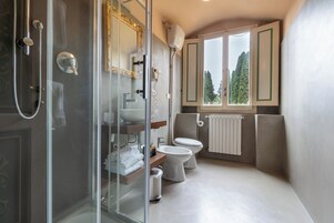 A modern bathroom with a glass shower enclosure, a toilet, and a sink.