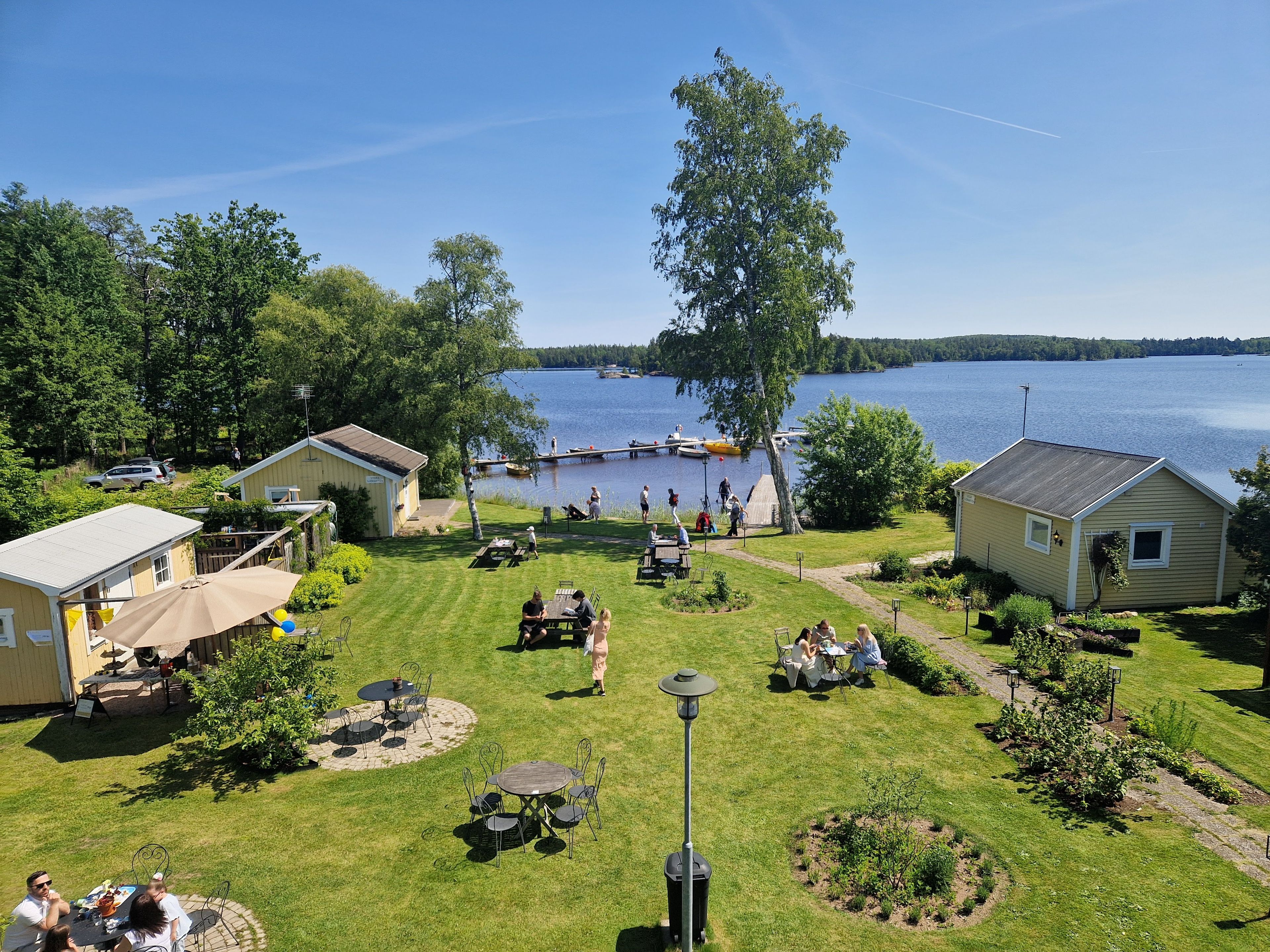 A lakeside property with outdoor seating, a dock, and a grassy lawn.