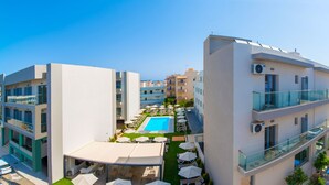Un edificio moderno con piscina, area relax all'aperto e cielo azzurro.