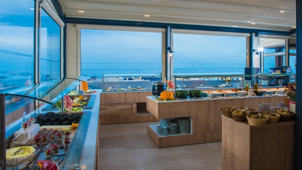 Angolo buffet con vista sull'oceano, caratterizzato da diverse pietanze e un design moderno.