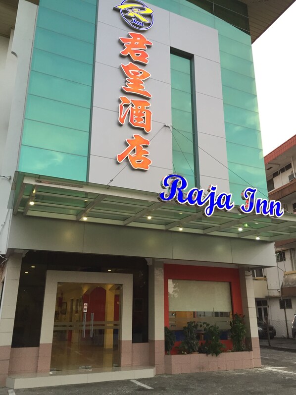 A hotel with a sign reading "Raja Inn" and Chinese characters above it.
