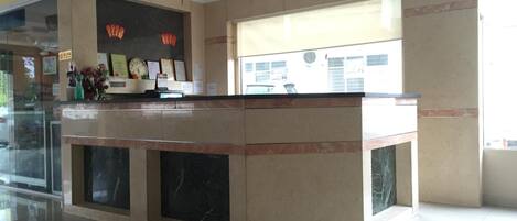 A reception area with a marble counter, a large window, and red lanterns.