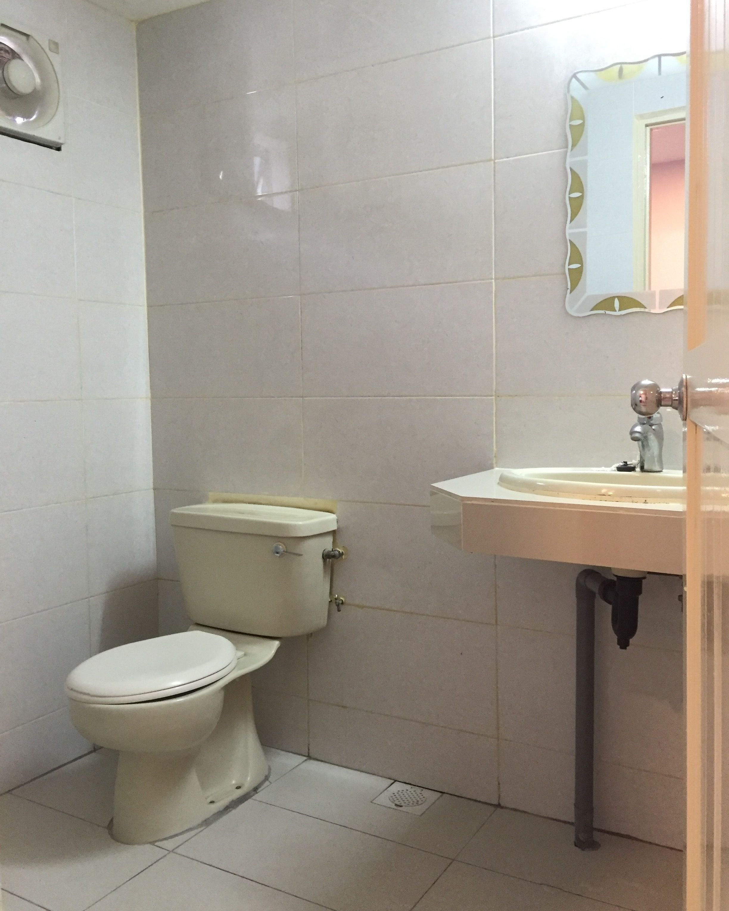 Une petite salle de bain avec des toilettes, un lavabo et un miroir.