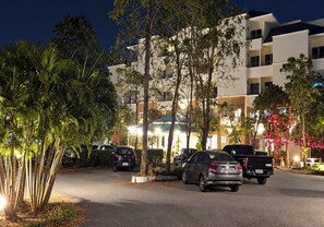 A parking area with multiple cars, a building with balconies, and trees. - Udoncabana (Udon Thani)