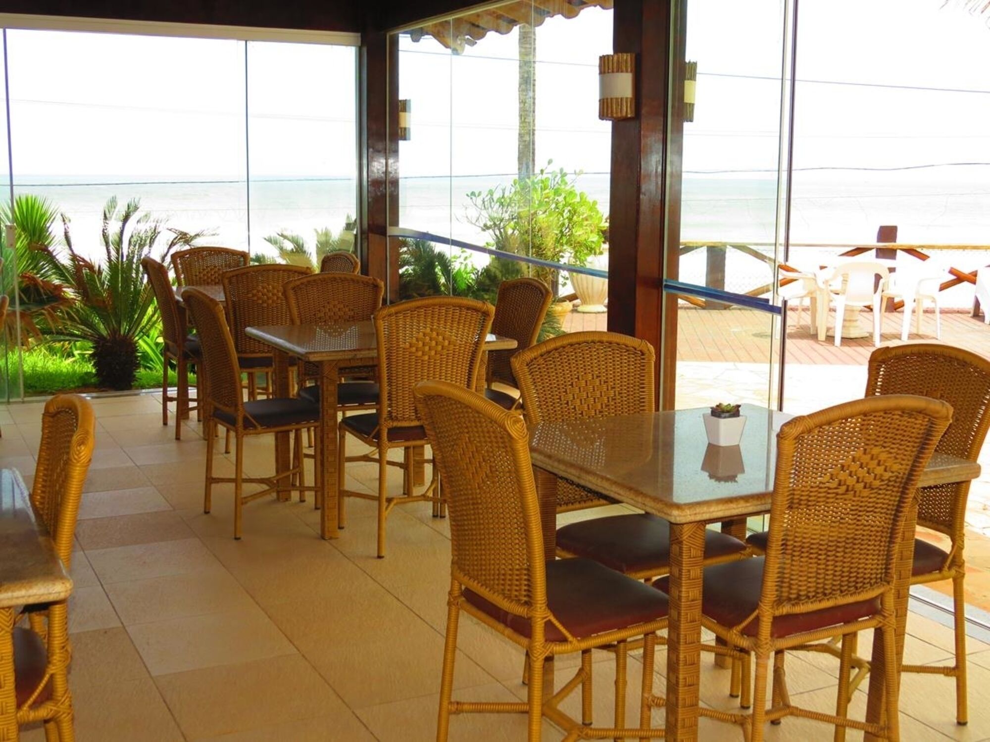 An outdoor dining area with wicker furniture and a view of the ocean.