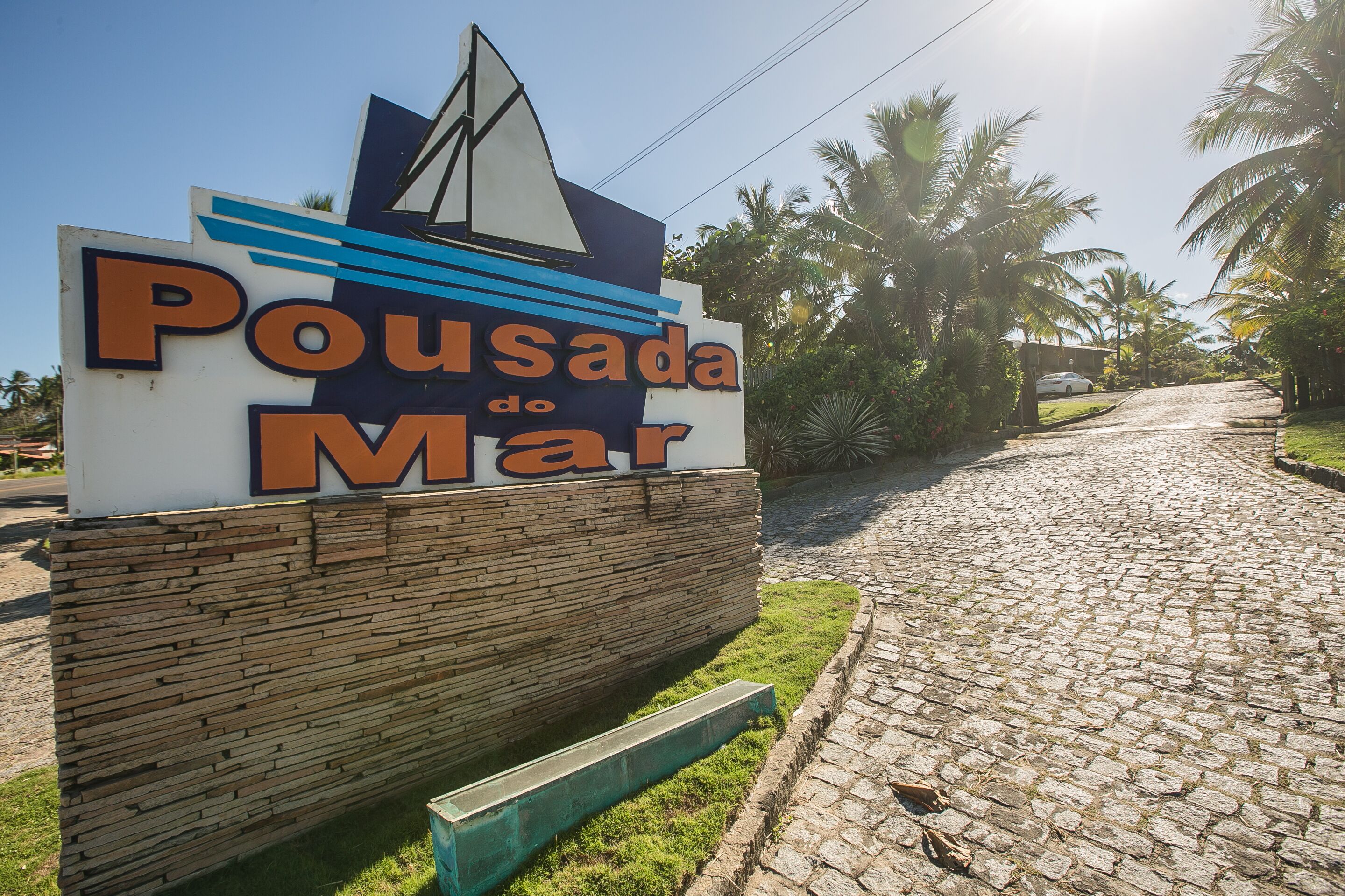 A sign for 'Pousada do Mar' with a nautical theme, including a sailboat graphic.