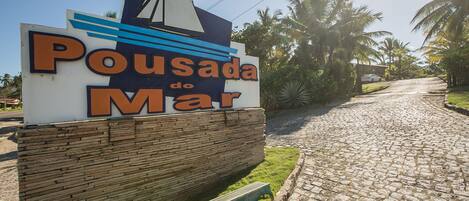 A sign for 'Pousada do Mar' with a nautical theme, including a sailboat graphic.