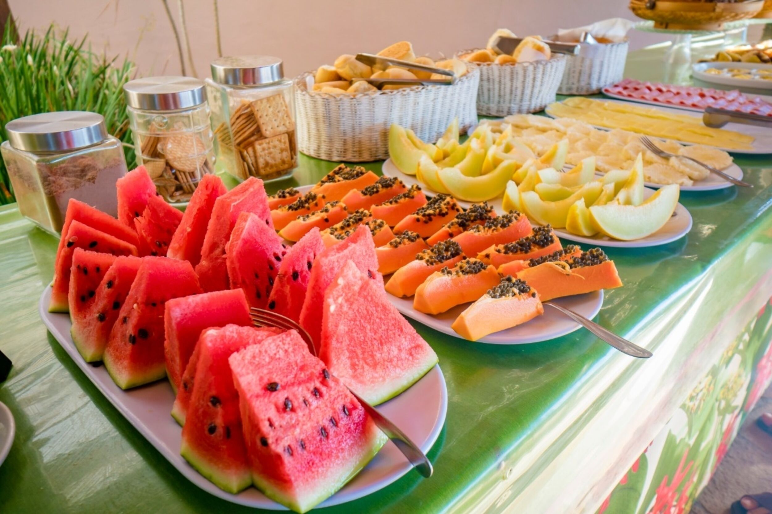 A buffet table with various fruits and snacks.