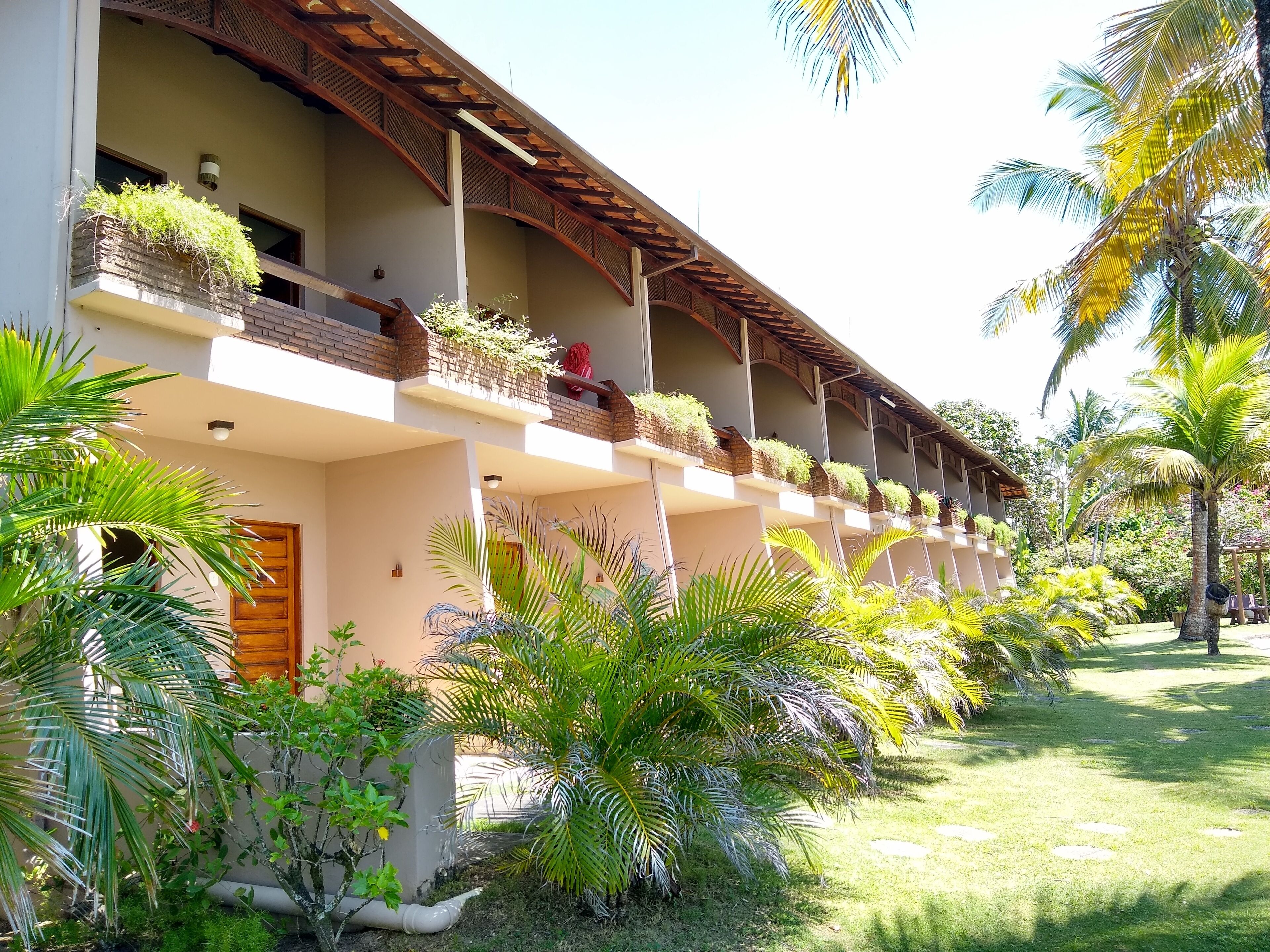 Un hotel con varios balcones, cada uno decorado con plantas y barandilla de madera.