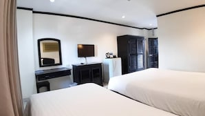 A hotel room with two beds, a desk with a flat-screen TV, a wardrobe, and a mirror. - Essential Pattaya (Pattaya)