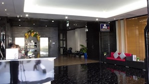 A modern lobby with a reception desk, seating area, and a sign for the M Shop. - Essential Pattaya (Pattaya)